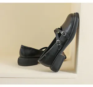 Close-up of black platform Mary Jane shoes with crisscross straps and silver buckles