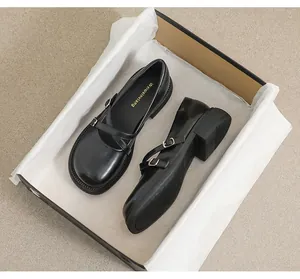 Close-up of black platform Mary Jane shoes inside an elegant black shoebox with dust paper