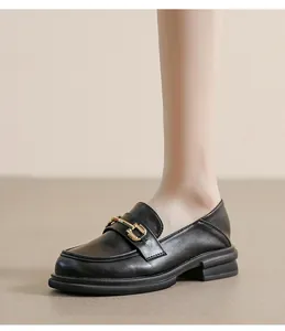 Detail of black leather platform loafers featuring a vintage gold horsebit metal buckle