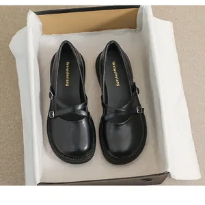 Unboxing detail of black Mary Jane loafers with crisscross straps and platform sole