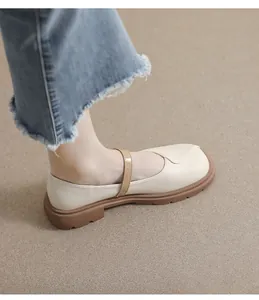 Vue portée de chaussures Mary Jane crème avec semelles épaisses en gomme et jean