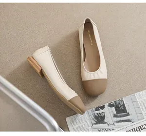 Detail view of square-toe flat shoes with contrast cap toe and perforated design