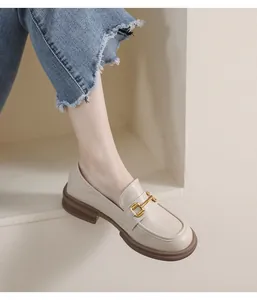 Close-up of beige leather loafers with gold horsebit buckle and anti-slip rubber sole