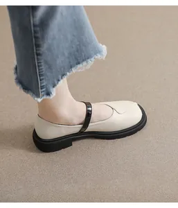 Chaussures Mary Jane beiges à plateforme portées avec un jean bleu sur fond neutre