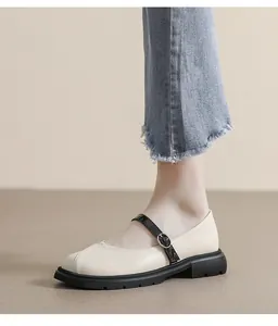 Détail de chaussures Mary Jane crème avec bride noire et semelle plateforme sur modèle