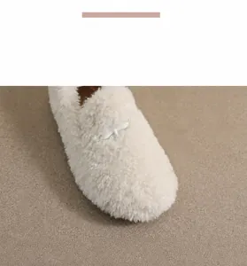 Macro view of plush faux fur texture and cross buckle on white microfiber flats
