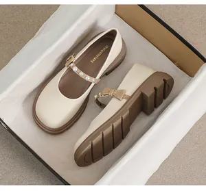 Close-up of Mary Jane platform shoe with pearl bow detail and thick rubber sole