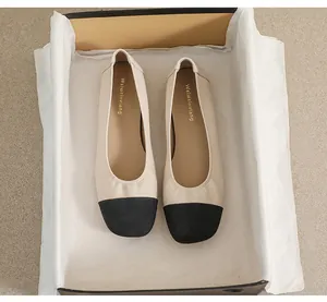 Detailed top view of classic two-tone square toe flat shoes inside a premium box