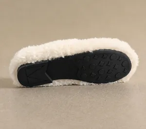 Macro detail of the non-slip rubber outsole with star textures and soft faux fur lining