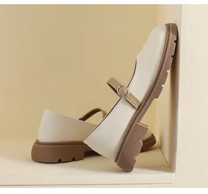 Détail de chaussures Mary Jane beige à plateforme avec bride brune et semelle crantée