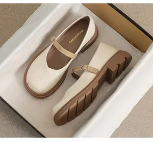 Détail de chaussures Mary Jane crème avec semelles crantées marron dans leur boîte