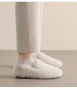 Side view of cream fuzzy faux fur loafers with soft plush texture and black flat soles