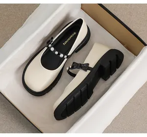 Top view of platform Mary Jane shoes with pearl and bow details inside a premium box