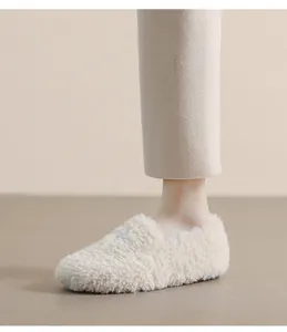Detail view of cream plush faux fur loafers with bow tie and non-slip sole for winter