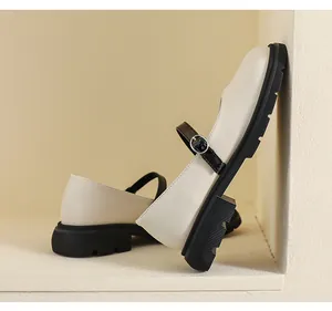 Détail de chaussure Mary Jane beige avec semelle plateforme noire et bride à boucle métal