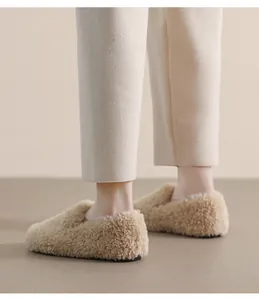 Close-up of beige faux fur flat shoes with soft texture and warm rounded toe
