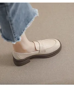 Detalle de mocasines con plataforma en cuero beige mate y suela dentada marrón