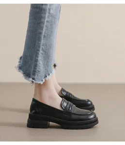 Detalle de mocasines negros de plataforma con correa de silla y suela gruesa antideslizante