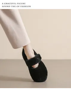 Dettaglio di ballerine Mary Jane nere in peluche indossate con pantaloni color crema