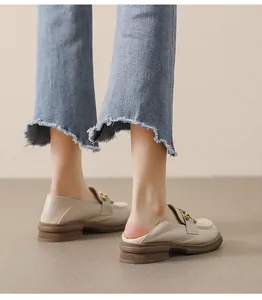 Vue détaillée de mocassins beiges à plateforme avec une chaîne dorée décorative