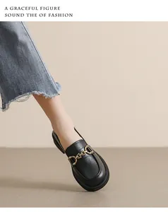 Détail de mocassins en cuir noir avec boucle dorée portés avec un jean en denim