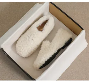 Detail of cream faux shearling loafer shoes with soft plush texture and black flat sole