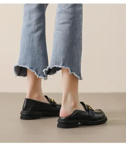Vue détaillée de mocassins mules en cuir noir mat avec semelle épaisse et chaîne dorée