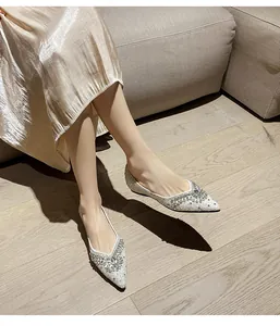Eleganti ballerine a punta con strass scintillanti indossate in un ambiente accogliente