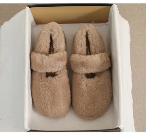 Dettaglio di ballerine in peluche color cammello in una confezione regalo di lusso