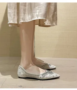 Dettaglio di eleganti ballerine a punta con paillettes argento e strass scintillanti