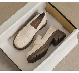 Vista superior de mocasines de plataforma crema con suelas gruesas de goma marrón en caja