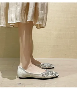Dettaglio delle ballerine a punta argento con paillettes e decorazione in cristallo