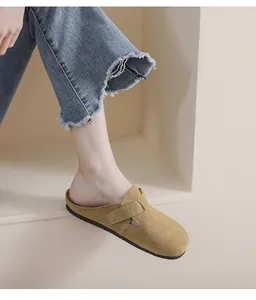 Dettaglio dei sabot in pelle scamosciata kaki con fibbia regolabile e suola piatta comoda