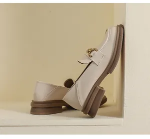 Détail des mocassins beiges avec boucle dorée et semelles épaisses marron élégantes
