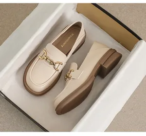 Gros plan de mocassins beige à plateforme avec boucle mors dorée en boîte