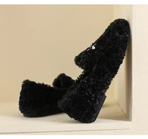 Close-up of black fuzzy faux fur flat loafers with soft plush texture for winter