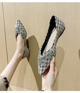 Dettaglio di eleganti ballerine in tweed con fibbie a fiore in cristallo scintillante