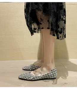 Dettaglio di eleganti ballerine a punta con strass scintillanti e tessuto in tweed