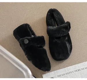 Dettaglio di scarpe basse in pelliccia nera con cinturino e fibbia in metallo chic