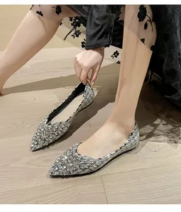 Dettaglio di ballerine a punta argentate con strass luccicanti e suola piatta elegante