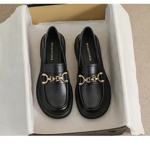 Détail de mocassins en cuir noir avec boucle dorée et semelle intérieure confortable