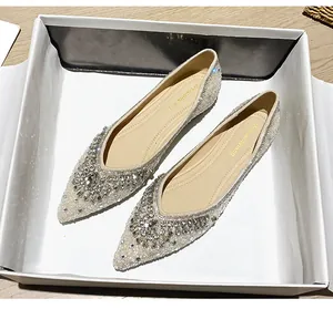 Dettaglio macro di ballerine a punta con strass scintillanti e motivo floreale in cristallo