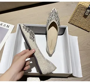 Dettaglio di scarpa piatta beige a punta con motivi di strass scintillanti e suola morbida