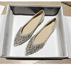 Dettaglio di scarpe basse a punta con decorazioni in cristallo lucido nella scatola regalo