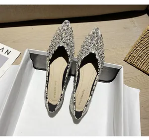 Dettaglio di ballerine a punta con strass scintillanti e bordi in motivo pied-de-poule