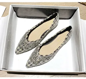Dettaglio di ballerine a punta con strass luccicanti e rifiniture in motivo pied de poule