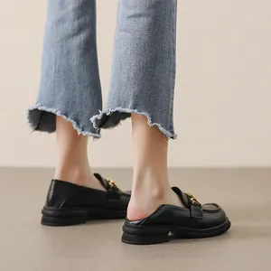 Mocassins à plateforme noirs avec chaîne dorée et jean en denim à bords effilés