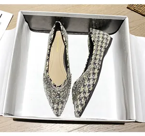 Dettaglio di scarpe basse a punta con motivo pied-de-poule e fibbia in strass lucidi
