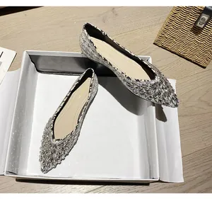 Dettaglio delle scarpe basse a punta con decorazioni in strass argentati scintillanti