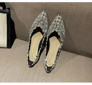 Dettaglio delle ballerine a punta in tweed bianco e nero con lussuose decorazioni in strass